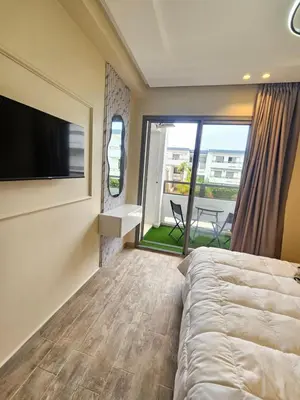 a bedroom with a bed and a flat screen tv at Appartement El Mansouria Séjour Luxueux Plage & vue Piscine in Mansouria