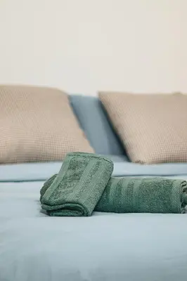 a green towel sitting on top of a bed at Lagoon Garden - 2 chambres proche Plage avec Piscine in Skhirat