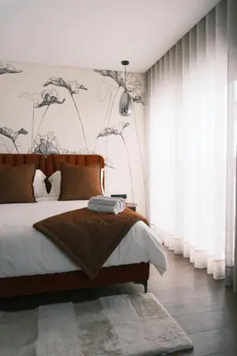 a bedroom with a bed and a wall with flowers at Luxury Warm-Wood Duplex - Rooftop Sky Pool Access in Casablanca