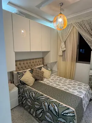 a bedroom with a bed with a comforter at Appartement abwab tamaris in Dar Mouddene