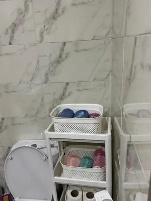 a bathroom with a white toilet and a marble wall at Appartement abwab tamaris in Dar Mouddene