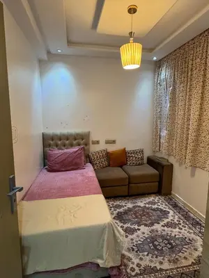 a bedroom with a bed and a couch at Appartement abwab tamaris in Dar Mouddene