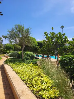 a garden with yellow flowers and a swimming pool at Superbe appartement de 3 chambres avec piscines in Tamaris