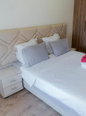 a large bed with white sheets and pillows at cozy appartement, convenient local in Casablanca
