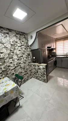 a kitchen with a stone wall and a table and a counter at Tamaris in Casablanca