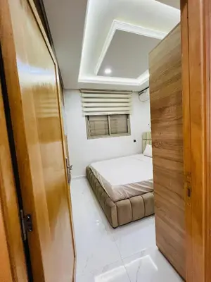 a small bedroom with a bed and a window at Modern Apartment Bouznika in Bouznika