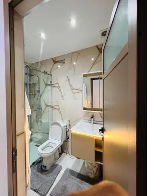 a bathroom with a toilet and a sink and a shower at Modern Apartment Bouznika in Bouznika