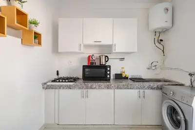 a kitchen with white cabinets and a microwave at Modern 1 Bedroom W Terrace-Arribat Center in Rabat