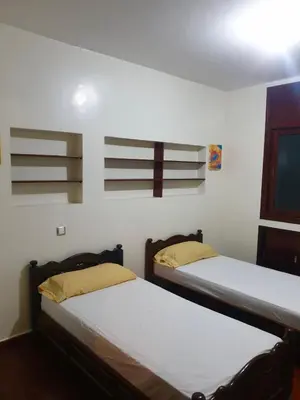 two beds in a room with white walls at Appartement meublé Centre de Témara in Temara