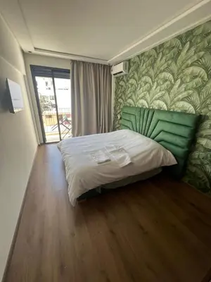 a bedroom with a large bed with a green headboard at Adam résidence in Casablanca