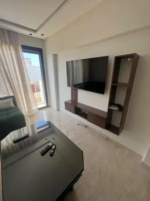 a living room with a flat screen tv and a couch at Adam résidence in Casablanca