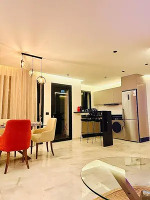 a living room with a table and chairs and a kitchen at Cozy Studio Steps from Med V Stadium in Casablanca