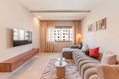 a living room with a couch and a tv at L'Horizon - 1 BR - Pool & Terrace in Nouaseur