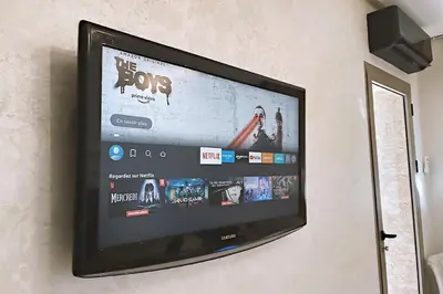 a flat screen tv hanging on a wall at Modern apartment with pool parking in O Ben Slimane