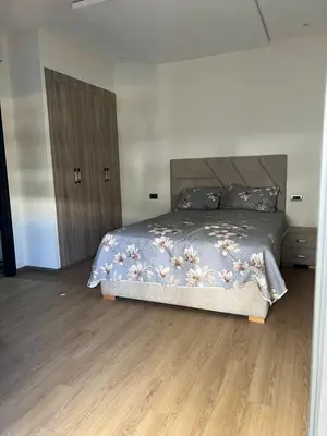 a bedroom with a bed and a wooden floor at Appartement Èlégant Vue piscine in Casablanca