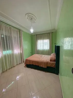 a bedroom with a bed in a room with green walls at Cozy apartment in Skhirat near Rabat in Skhirat