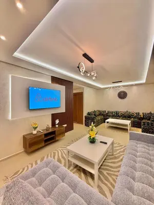 a living room with a couch and a tv on a wall at N22 Élégance et Confort à La Corniche Rabat - Appartement de Luxe Essabah in Rabat