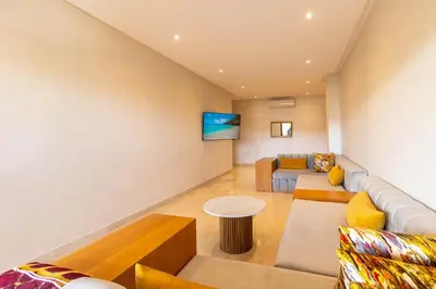 a living room with a couch and a table at Family apartment Terrace Pool Wi-Fi in O Ben Slimane