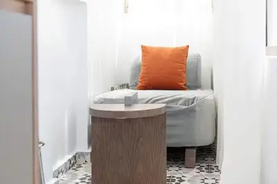 a bed with an orange pillow on top of a table at Mansouria 1BR Pool View Beach Parking in Mansouria
