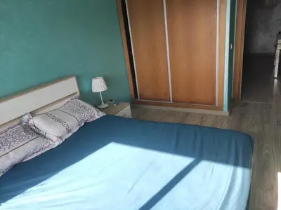 a bedroom with a bed and a wooden cabinet at Mansbay Beach Dalia in Mohammedia