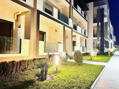 a building with a light on the side of it at Elegance Pool View Apartment in Dar Bouazza