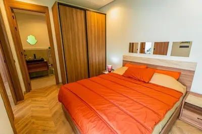 a bedroom with an orange bed and a bathroom at Graffiti Chill Zone - Calme en plein Centre in Casablanca
