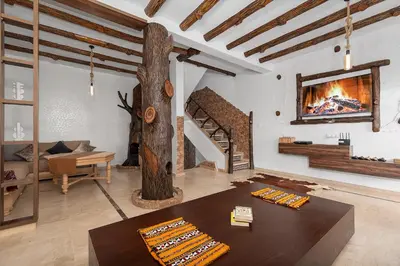 a living room with a fireplace and a table at Harhoura Luxury Stay, Steps from the Beach in Temara