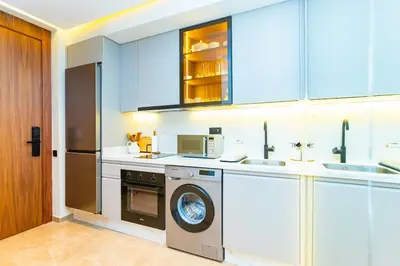 a kitchen with white cabinets and a washer and dryer at Cozy and new apartment in Princesses in Casablanca