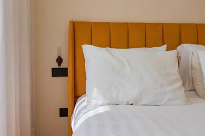 a bed with white pillows and a wooden headboard at Cozy and new apartment in Princesses in Casablanca