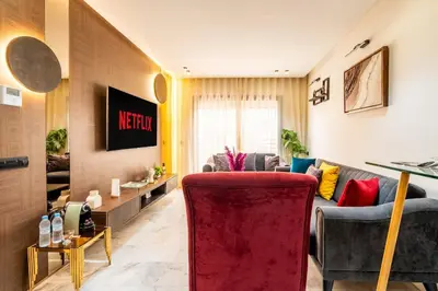 a living room with a couch and a red chair at Awesome place with city view maarif casablanca in Maarif