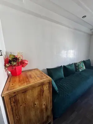 a living room with a blue couch and a wooden table at chambre saada in Dar Bouazza