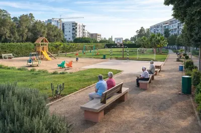 a group of people sitting on benches in a park at Cozy Apartment Near Airport in Nouaceur