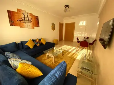 a living room with a blue couch and a glass table at Bourgogne Ocean Prestige in Casablanca