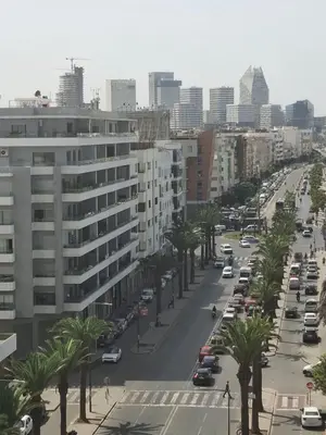 a city street with cars and palm trees and buildings at Luxurious and cozy CFC panoramic view studio in Casablanca