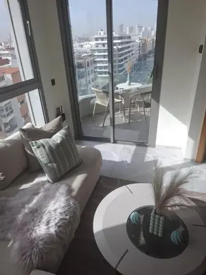 a living room with a couch and a table at Luxurious and cozy CFC panoramic view studio in Casablanca