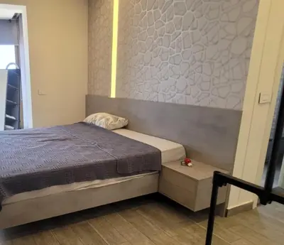 a small bedroom with a bed and a wall at Bel Appartement Spacieux et Lumineux Maarif in Casablanca