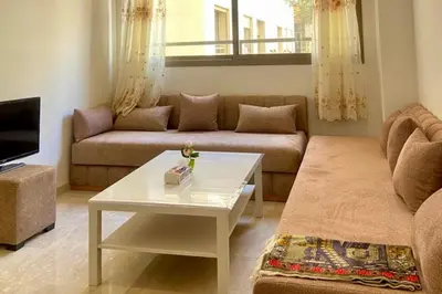 a living room with a couch and a coffee table at Appartement Moderne Équipé Proche Aéroport Mohammed V in Nouaseur