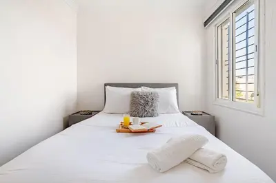 a bedroom with a white bed with white sheets and a window at Comfort Pool Apartment Heart of Tamaris in Tamaris