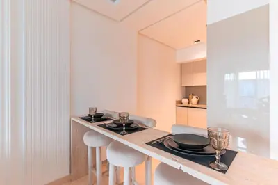 a kitchen with a counter with stools and plates on it at Chic Hotel-Style Apartment in Casablanca in Casablanca