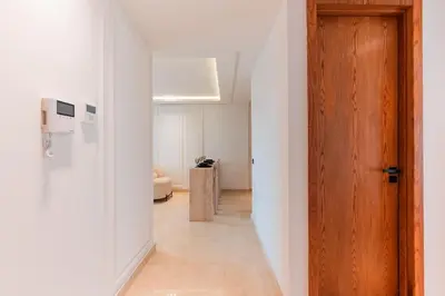 a hallway with a wooden door and white walls at Chic Hotel-Style Apartment in Casablanca in Casablanca