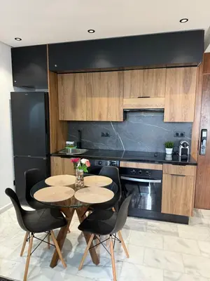 a kitchen with a table and chairs and a black refrigerator at Studio Le plus Beau Casablanca in Casablanca