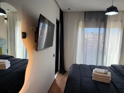a bedroom with two beds and a tv on a wall at Studio Best in Casablanca in Casablanca