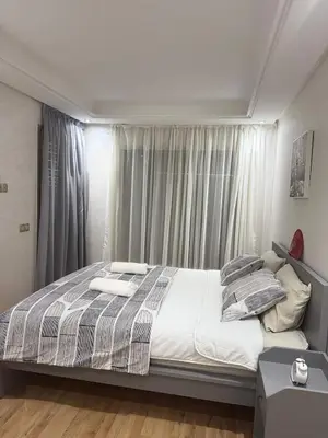 a bedroom with a large bed in front of a window at Appartement neuf avec piscine, balcon et à deux pas de la mer