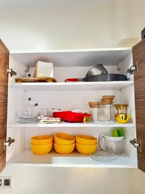 an open kitchen cabinet with bowls and utensils at Appartement de luxe in Casablanca