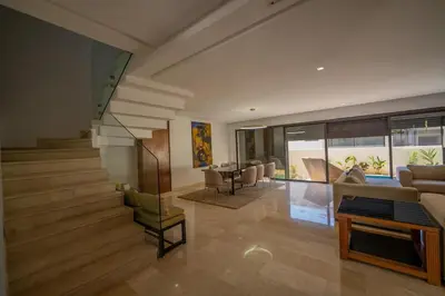 a living room with stairs and a table and chairs at Jack Beach Bay in Tamaris