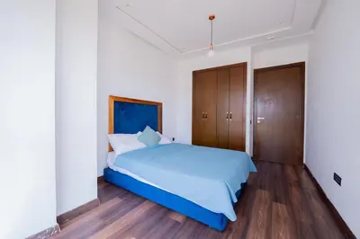 a bedroom with a blue bed and wooden cabinets at Jack Beach Bay in Tamaris
