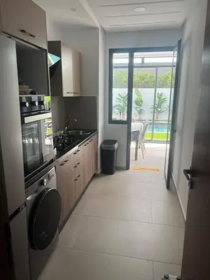 a kitchen with a large window and a table at Apartement avec piscine privée Casablanca in Casablanca