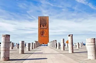a large brick clock tower with a row of pillars at Stay in Rabat with local in Rabat