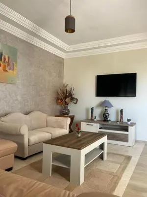 a living room with a couch and a flat screen tv at Appartement calme et lumineux à Harhoura in El Harhoura