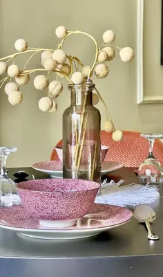 a table with pink plates and a bottle on it at Logement cosy avec terrasse in Casablanca